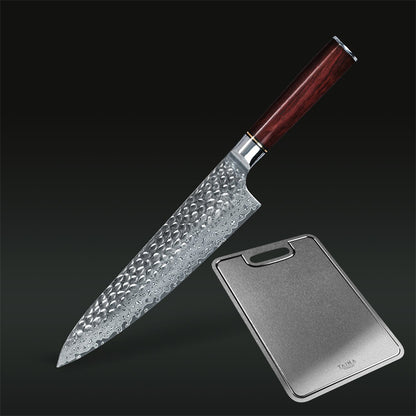 A kitchen knife with a hammered Damascus steel blade and a dark reddish-brown wooden handle, shown diagonally next to a rectangular metal cutting board on a dark gradient background.